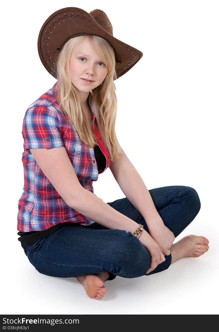 Beautiful girl in a cowboy hat sitting in the lotus position