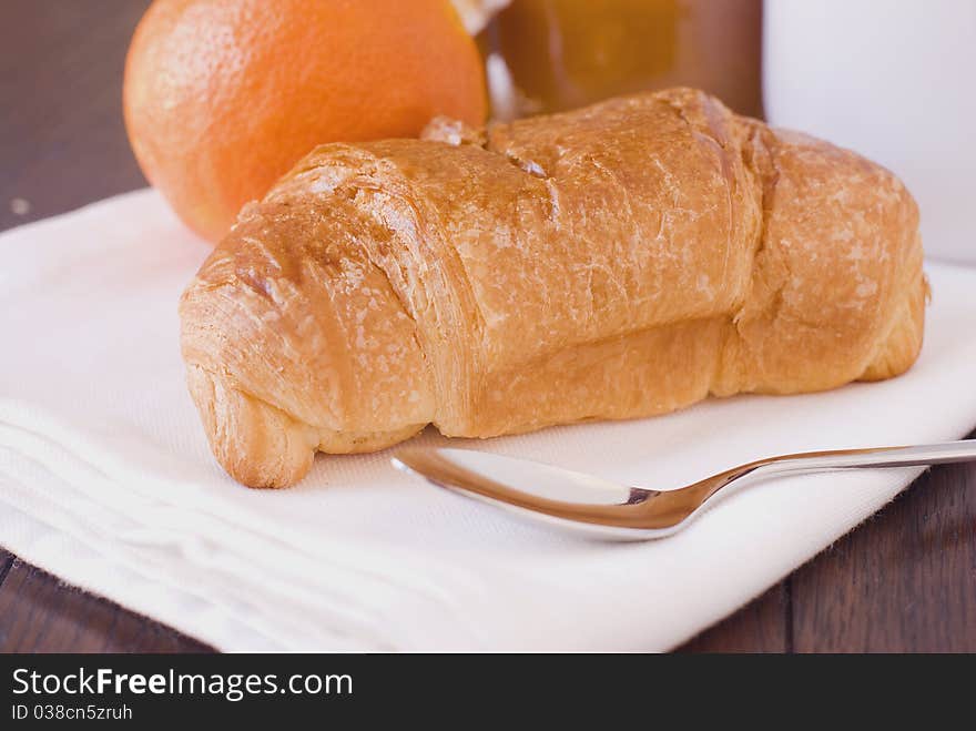 Breakfast with croissant, oranges and jam