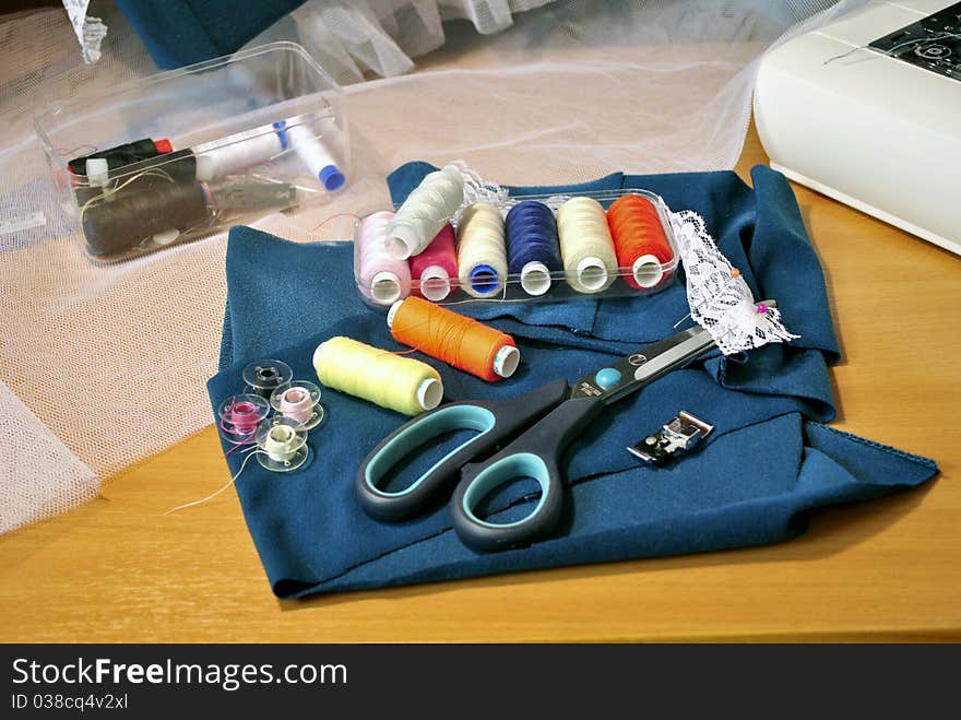 Accessories to sewing: scissors, a fabric, threads, coils. Accessories to sewing: scissors, a fabric, threads, coils