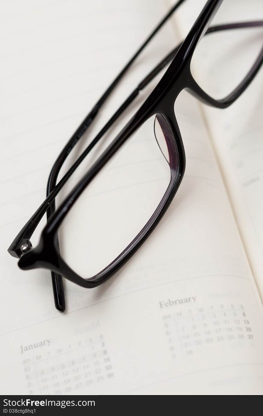 Glasses in black frames and paper notebook