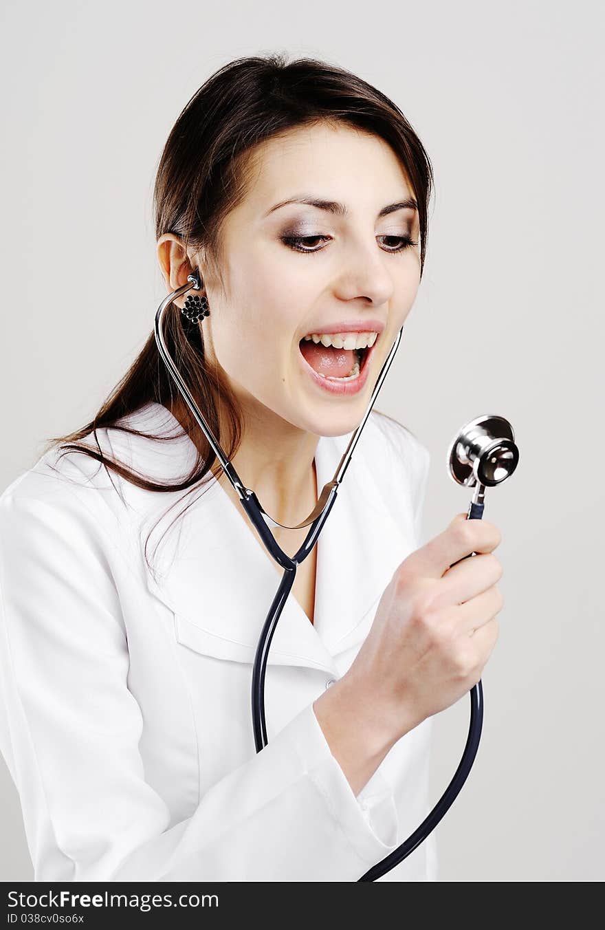 An image of young doctor shouts in a stethoscope. An image of young doctor shouts in a stethoscope