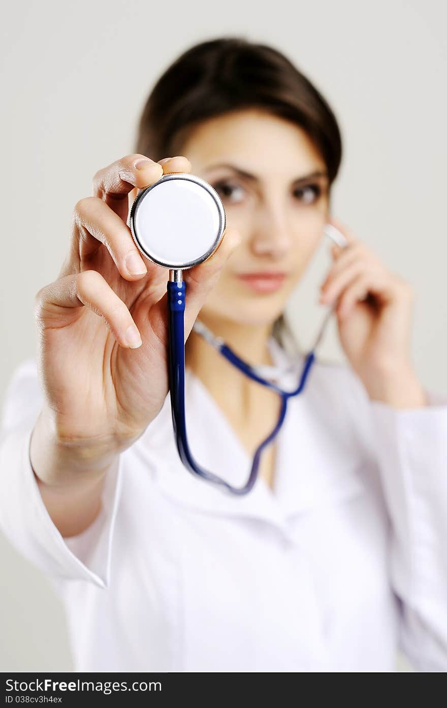 An image of young female doctor holding stethoscope to camera. An image of young female doctor holding stethoscope to camera