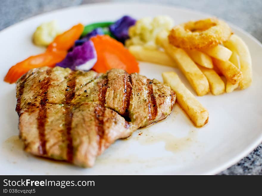 Grilled pork steak set with french fries and vegetable