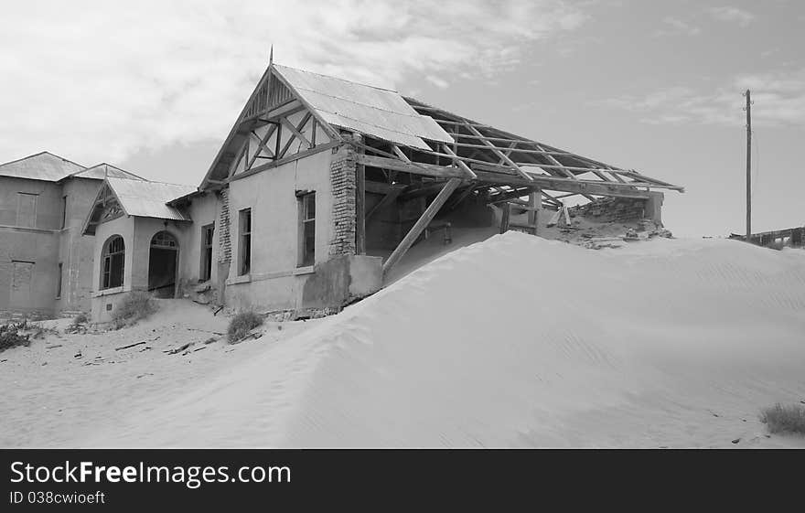 Kolemanskop near Ludritz, Black and white image of gosthouse with clouds. Kolemanskop near Ludritz, Black and white image of gosthouse with clouds