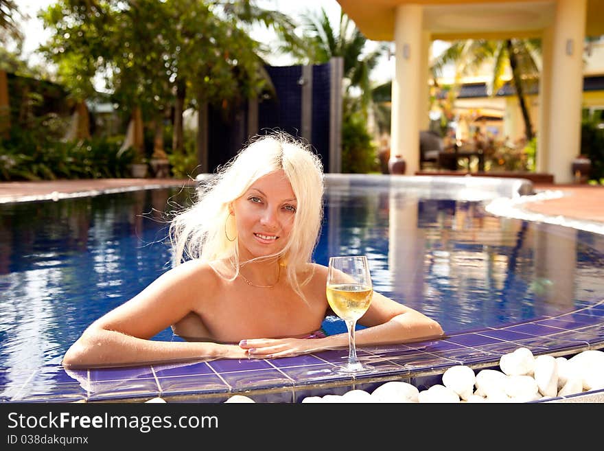 Young smiling women with cocktail in swimming pool. Young smiling women with cocktail in swimming pool