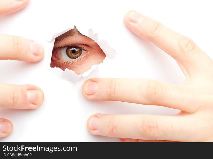 A man looks out a large hole in the white wall. A man looks out a large hole in the white wall