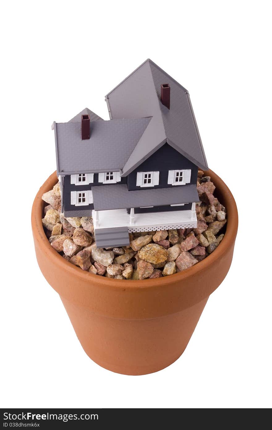 Model home on a small stone gravel in a clay flower pot.