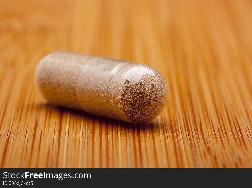 Medical pill against diseases on a wooden table.