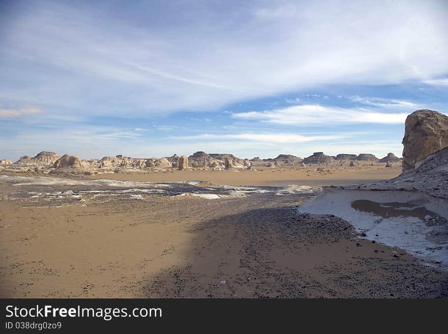 White desert landscape with rocksand white sand.