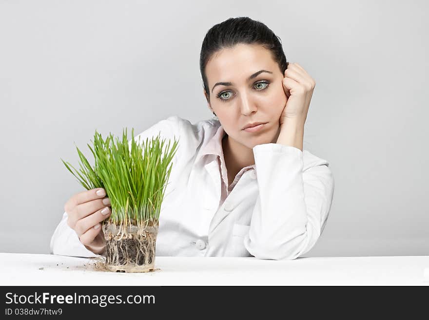 Worried girl watching a plant grow. Worried girl watching a plant grow.