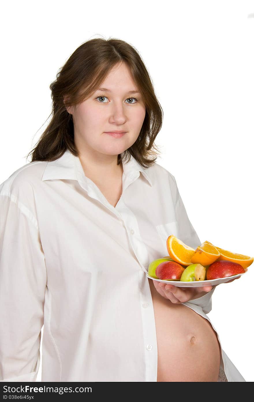 Adorable pregnant woman with fruits over white. Adorable pregnant woman with fruits over white