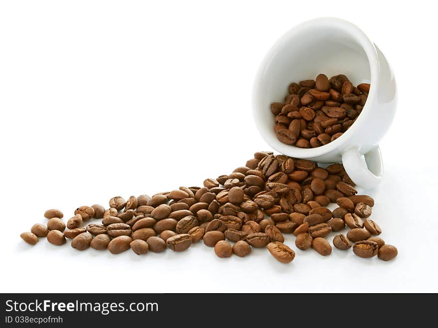 Brown roasted coffee beans in a white cup