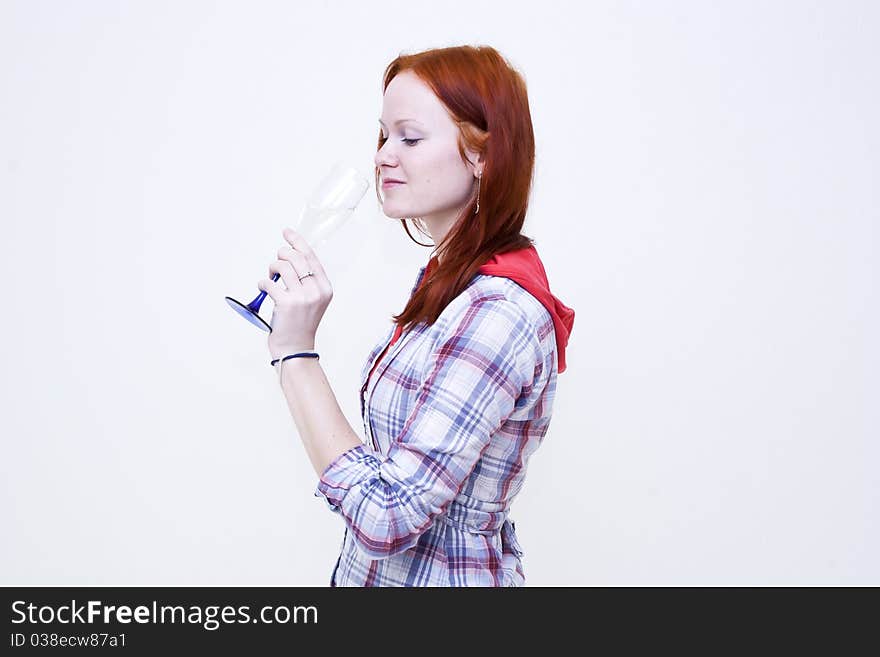 Redhead young woman is drinking from glass