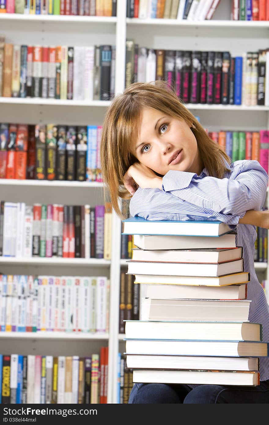 Young woman with books for reading in the library