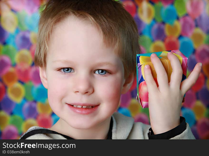 Young boy holding up a small gift. Young boy holding up a small gift