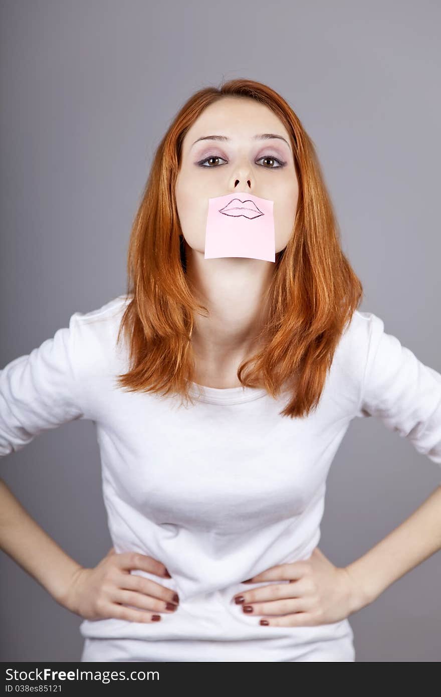 Portrait of red-haired girl with colorful funny stickers on mouth. Studio shot. Portrait of red-haired girl with colorful funny stickers on mouth. Studio shot.