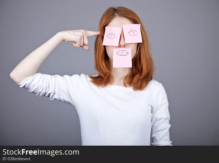 Portrait of red-haired girl with colorful funny stickers on mouth and eyes. Studio shot. Portrait of red-haired girl with colorful funny stickers on mouth and eyes. Studio shot.