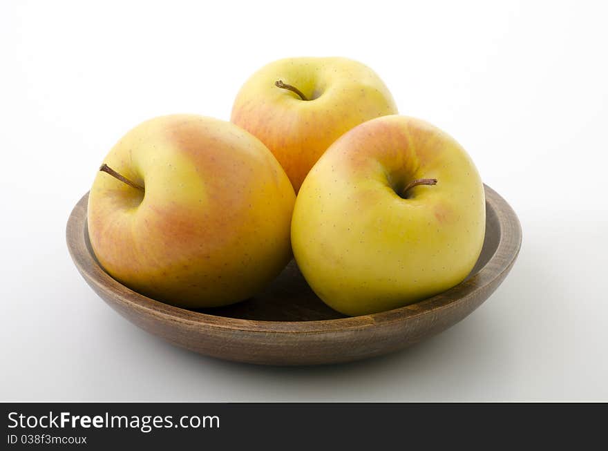 Three apples in a wooden bowl