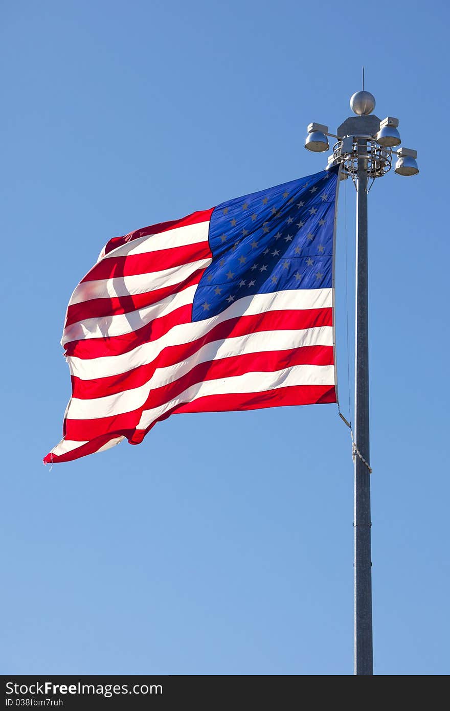 Beautiful red, white and blue US flag waving in the breeze with clear blue sky. Beautiful red, white and blue US flag waving in the breeze with clear blue sky