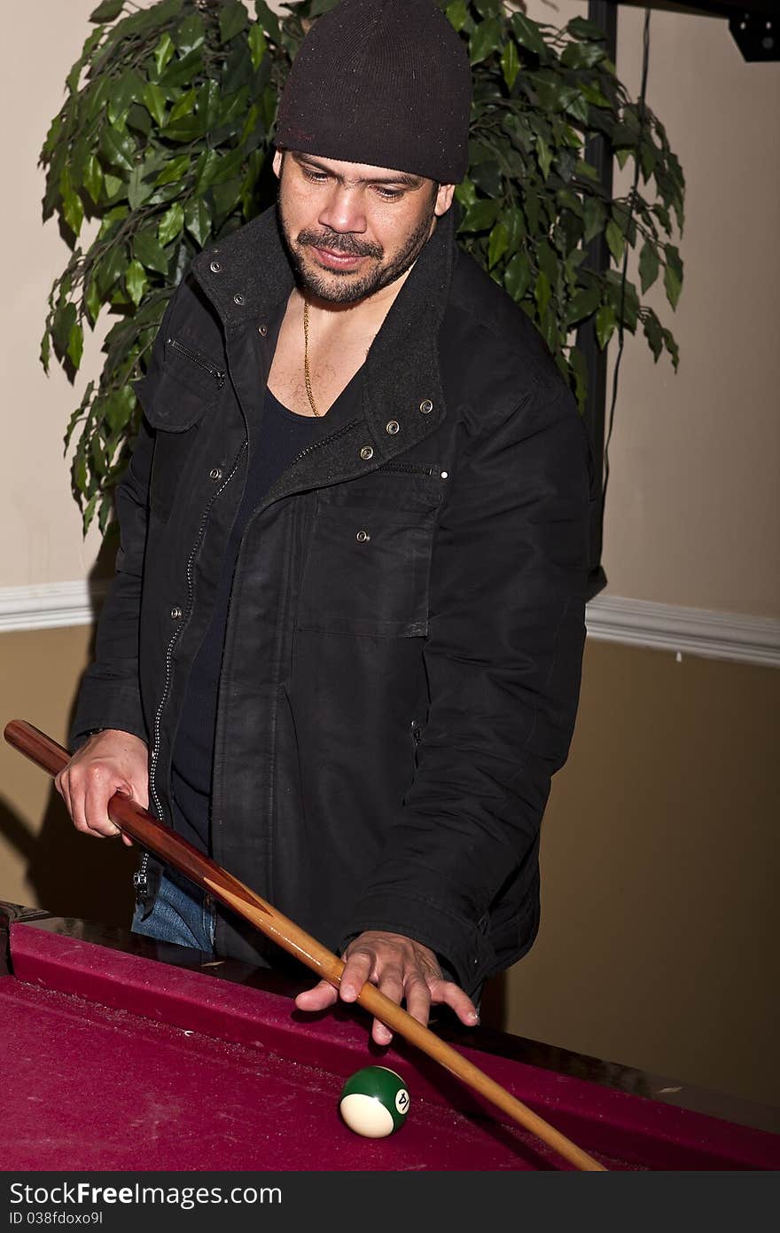 Latino guy playing pool table