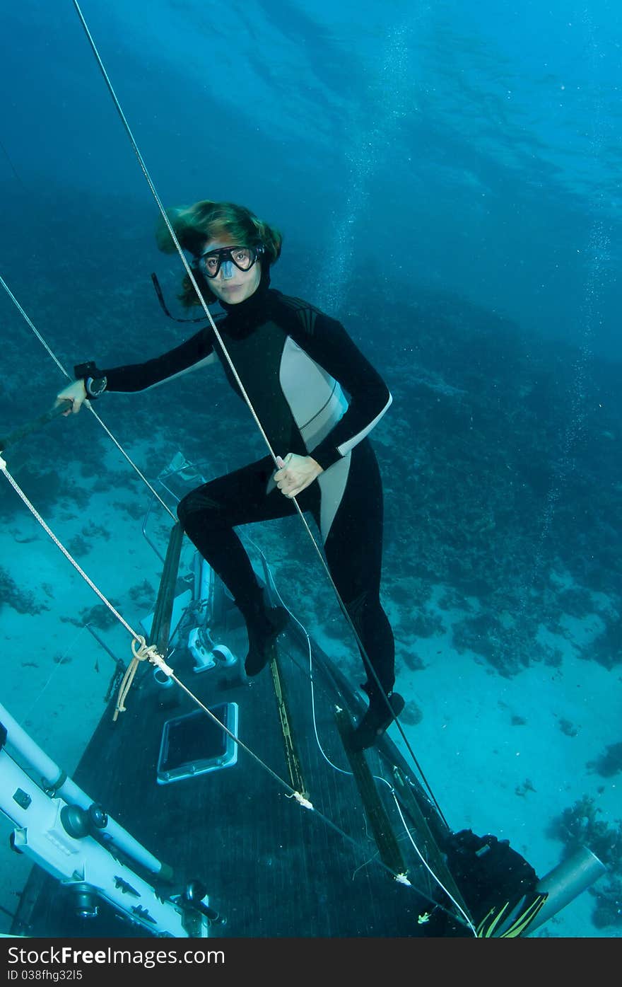 Free diver stands on underwater ship wreck in the red sea