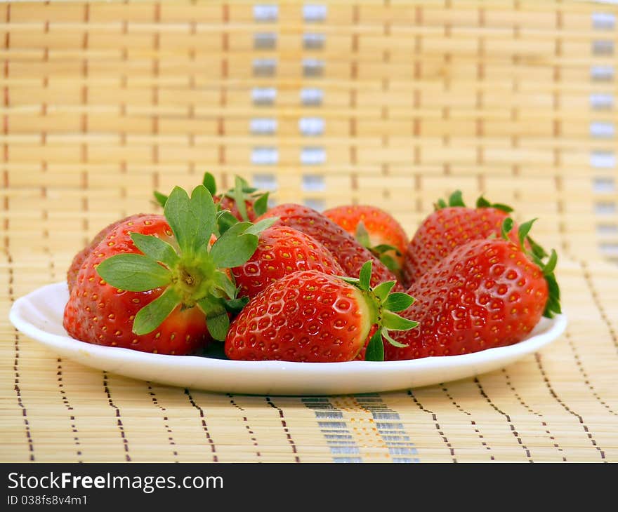 Appetizing large strawberry on a white plate