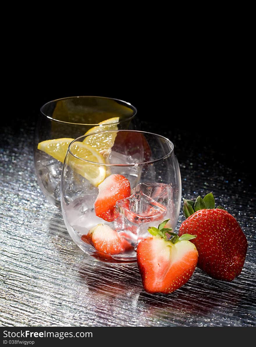 Photo of fresh strawberries and lemons on ice cubes. Photo of fresh strawberries and lemons on ice cubes