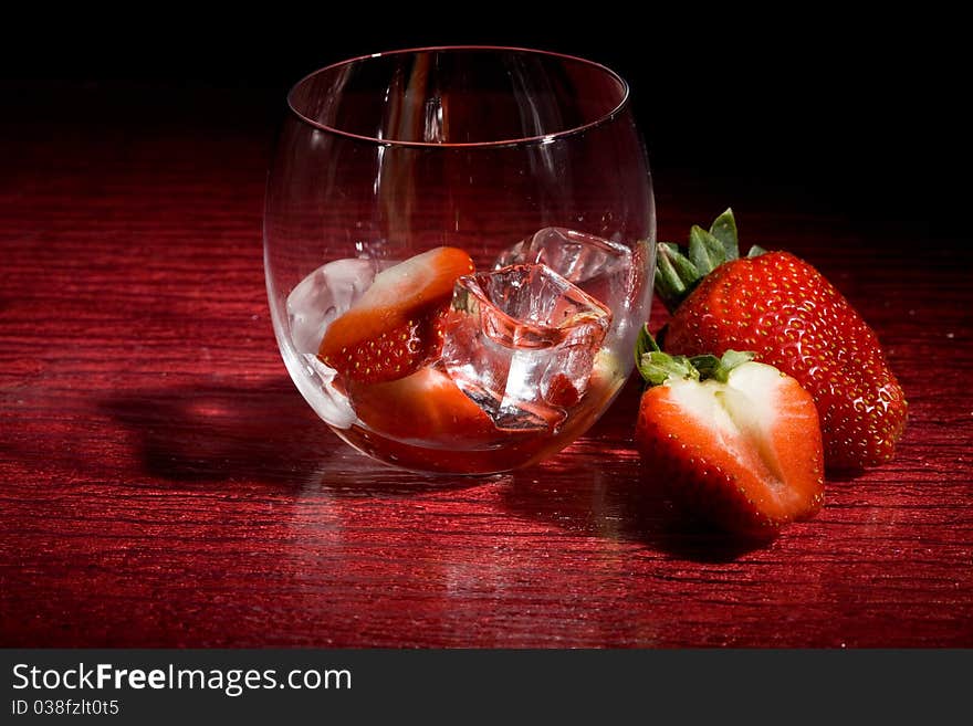 Photo of strawberries on ice on red table. Photo of strawberries on ice on red table