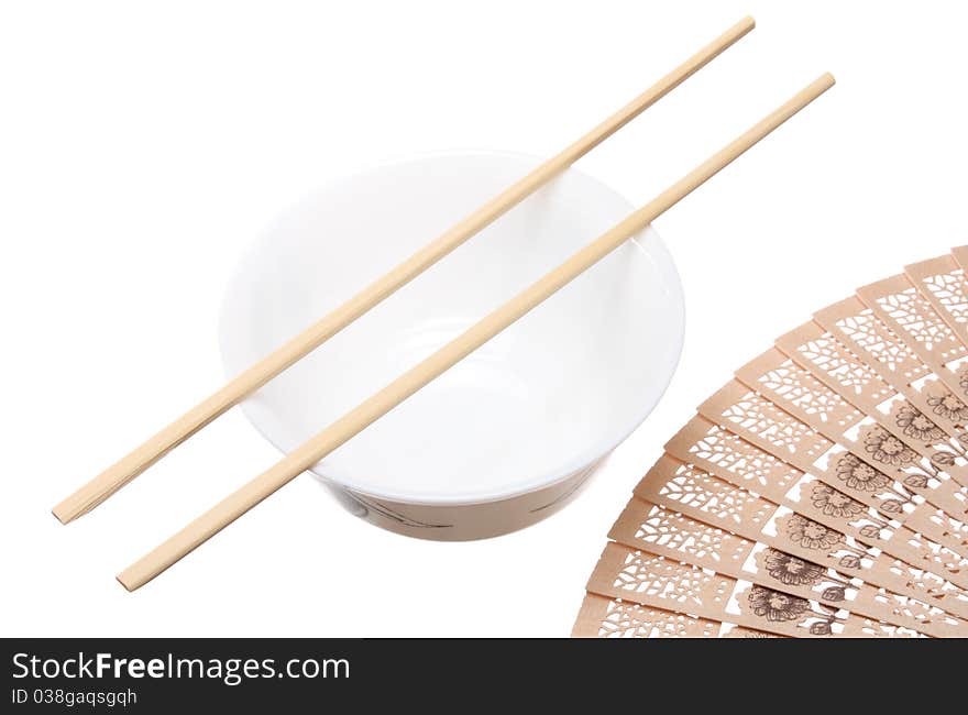 Chopsticks on the bowl and wooden fan isolated on white