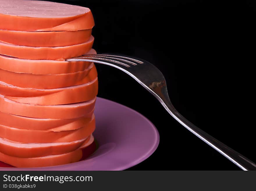 Sausage on the plate with fork