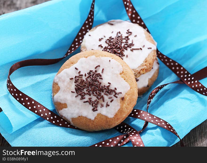 Cookies decorated with brown polka dots ribbon on the blue paper. Cookies decorated with brown polka dots ribbon on the blue paper