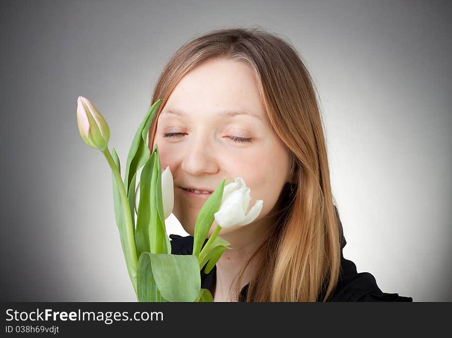 Young girl with tulips, with grey background. Young girl with tulips, with grey background