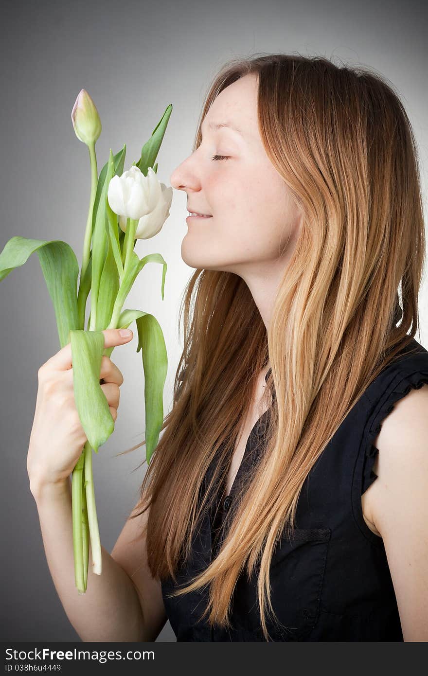 Young girl with tulips, with grey background. Young girl with tulips, with grey background