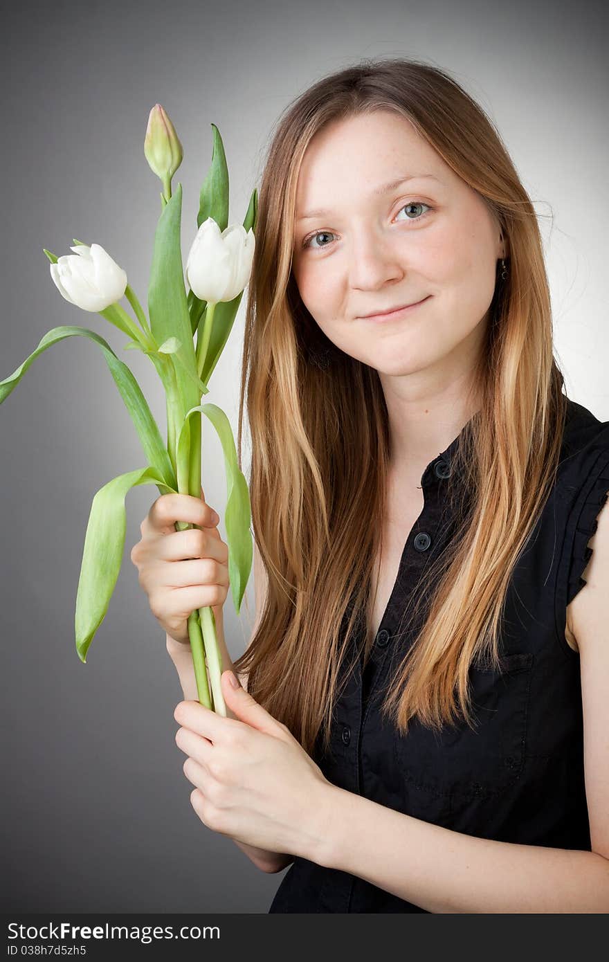 Young girl with tulips, with grey background. Young girl with tulips, with grey background