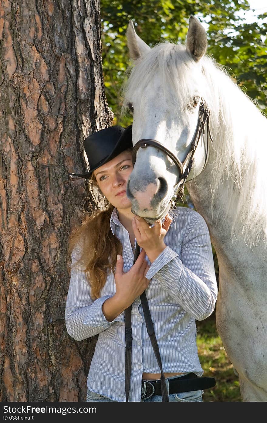 Portrait of young woman with her white horse in the woods. Portrait of young woman with her white horse in the woods