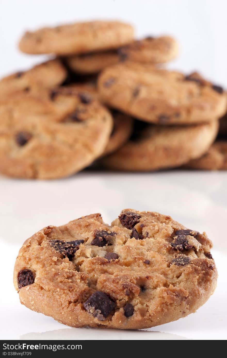 Pile of chocolate chip cookies, every cookie comes with a lot of chocolate chips, fresh baked just out of the oven isolated on white with copyspace