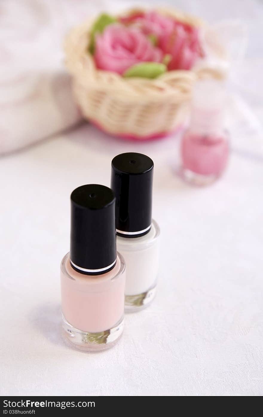 Pink and white enamels for French manicure, soap roses for hands care treatment, vertical