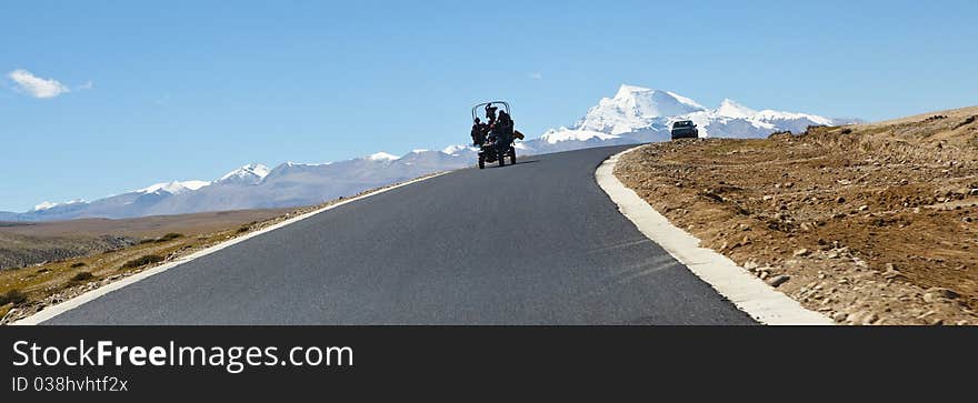 A group of tibetan people on tractor passing by mount naimonanyi (or gurla mandhata), burang, tibet. A group of tibetan people on tractor passing by mount naimonanyi (or gurla mandhata), burang, tibet.