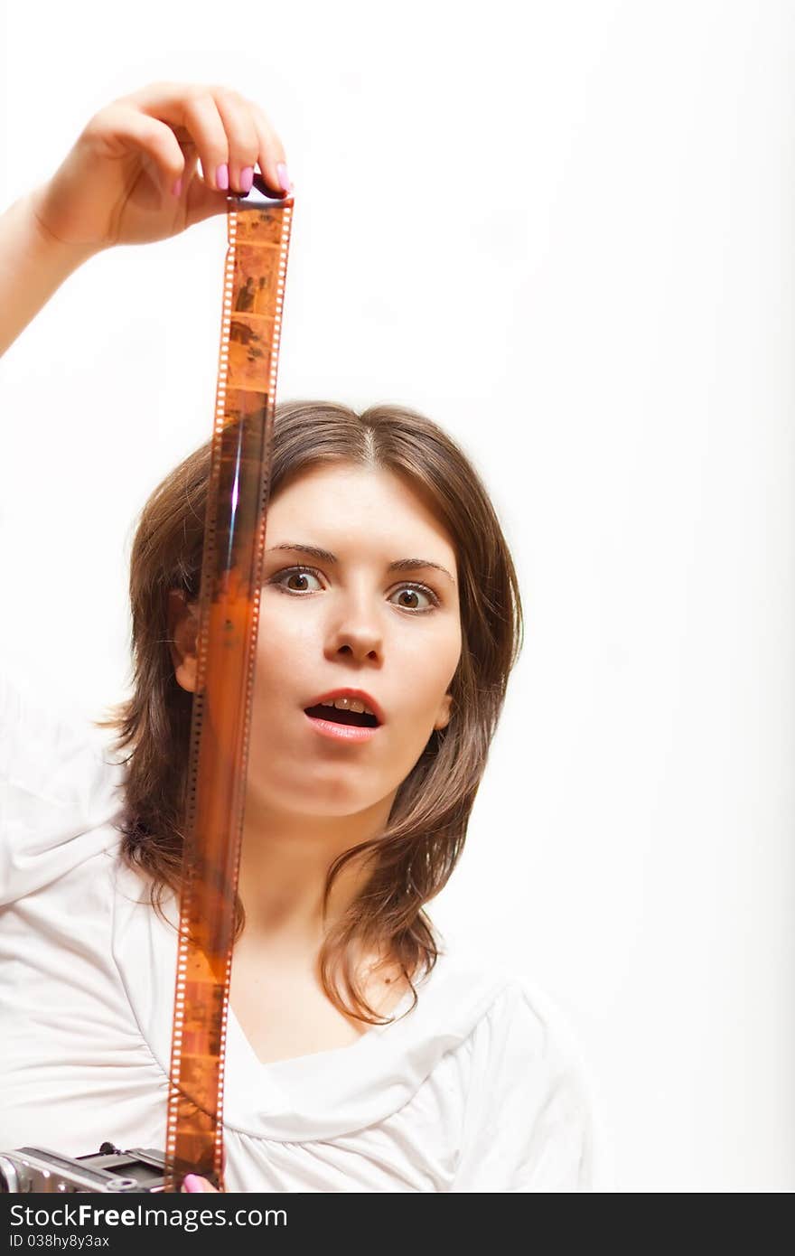 Surprised young woman looking at photofilm tape. on white background