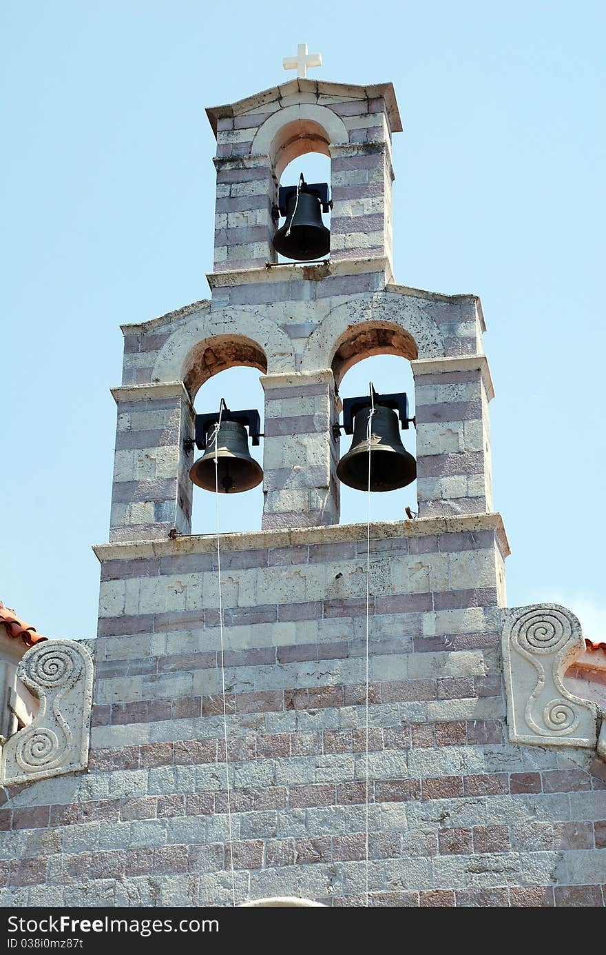 Old stone christian bell tower with three bells on sky background (Montenegro). Old stone christian bell tower with three bells on sky background (Montenegro)