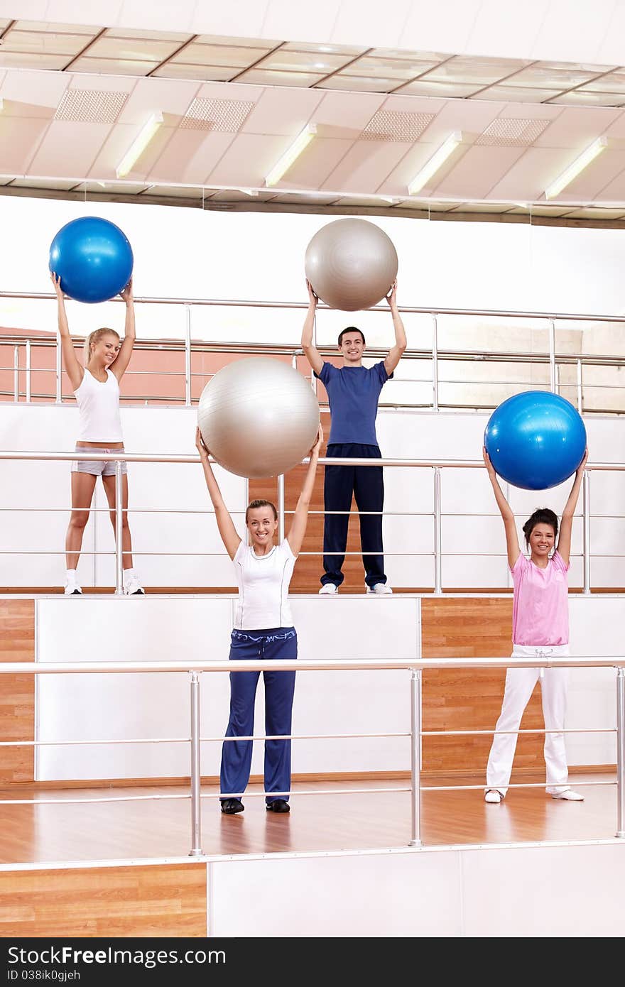 Young people are engaged in aerobic exercise with balls. Young people are engaged in aerobic exercise with balls