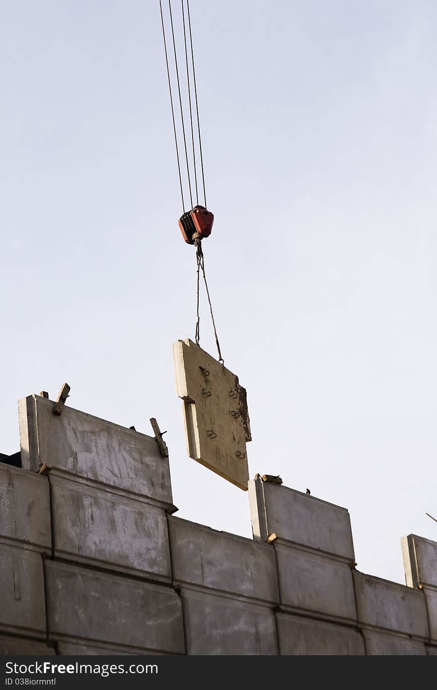 Crane putting up a huge slab on the gigantic wall. Crane putting up a huge slab on the gigantic wall.