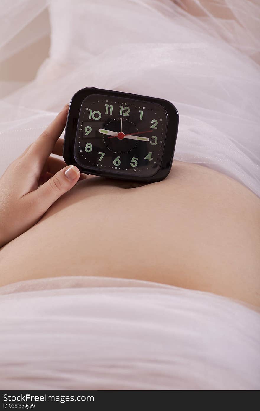 Mother expecting baby has a watch on her stomach