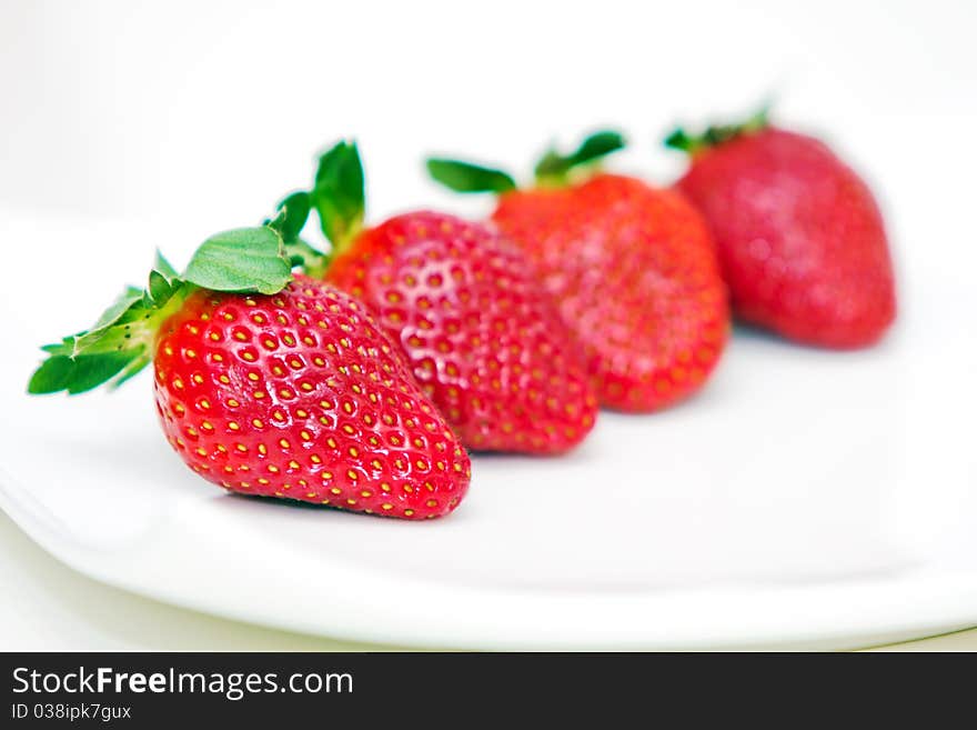 Isolated fruits - Strawberries on white plate.