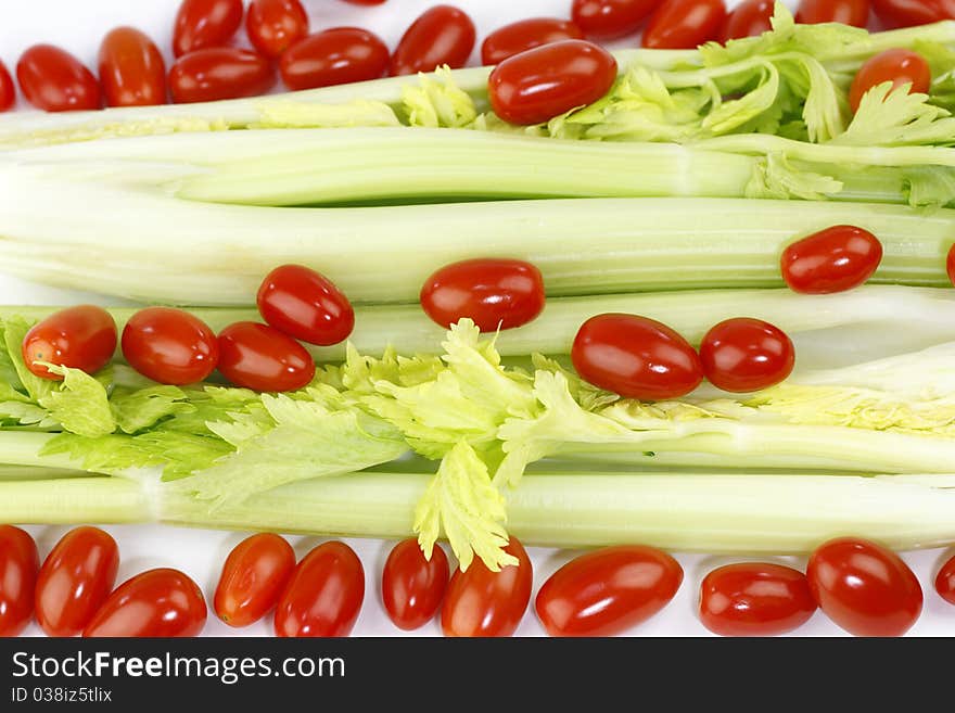 Fresh long green vegetable and small round red fruit mix on white. Fresh long green vegetable and small round red fruit mix on white.