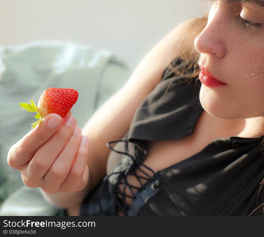 Young beauty with juicy red strawberry, focus on lips and on berry. Young beauty with juicy red strawberry, focus on lips and on berry