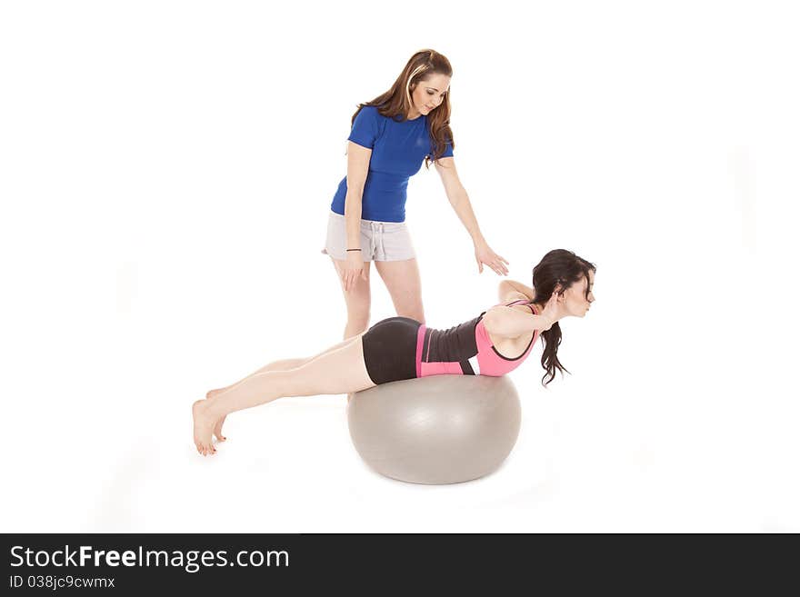 A woman is training another woman on a big ball. A woman is training another woman on a big ball.