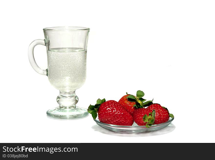 Red berries on a plate and a water glass. Red berries on a plate and a water glass