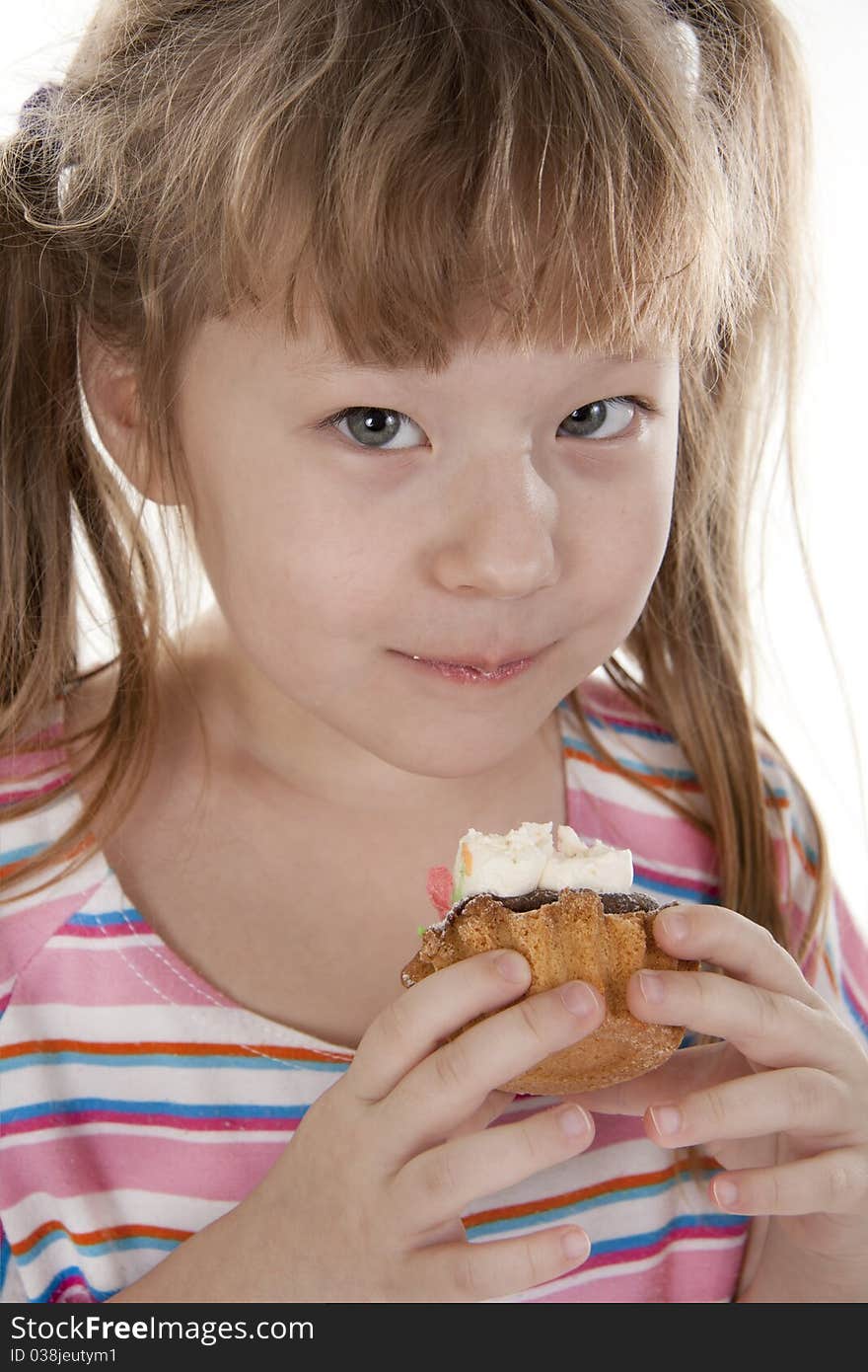 Small girl is eating cake. White isolated