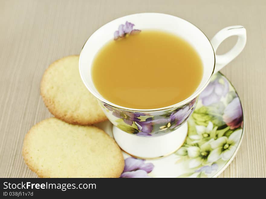 A china cup filled with Wassail, a hot spiced fruit punch, with homemade sugar cookies, selective focus on top of cup, top view. A china cup filled with Wassail, a hot spiced fruit punch, with homemade sugar cookies, selective focus on top of cup, top view